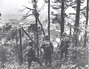 Soldiers of the 442nd/100th Regimental Combat Team stand on a shell-blasted hill overlooking the French town of Bruyères.  The unit wrested the town from German troops in a fiercely fought battle in October 1944.  Staff Sgt. Wada was awarded a Purple Heart for wounds suffered during the fight.