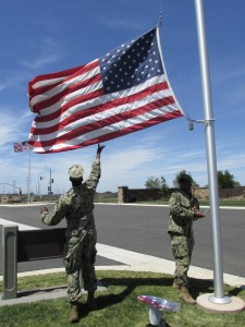 Navy SeaBees William Nickeo, left, and Sterlin Phillip, both of Seal Team 5, joined volunteers from the San Diego Armed Forces YMCA, May 1, to replace worn flags with new ones on the Miramar National Cemetery Avenue of Flags.